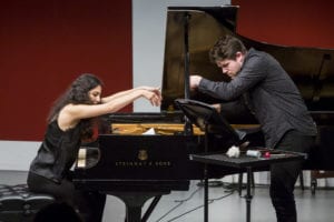 Two students play the strings of a piano during a concert of Tactus, the ensemble of the Contemporary Performance Program at Manhattan School of Music