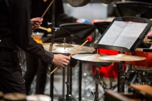 A Percussion student at Manhattan School of Music hits a cymbal with a mallet during a performance in Ades Performance Space